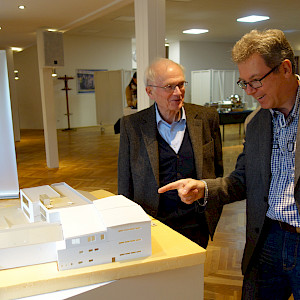 Ehrungsbrunch 2021 Peter Steepe und Rolf Ebert vor dem Modell des Bauprojekts Halenreie