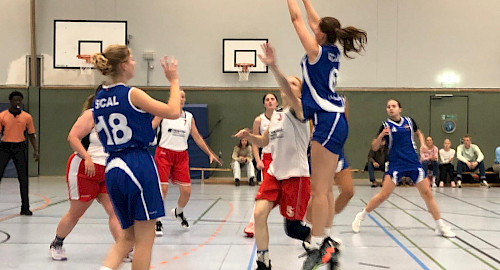 Spielerinnen auf dem Basketballcourt, blaue Trikots (SCAL) im Angriff gegen weiße Trikots (WSV)